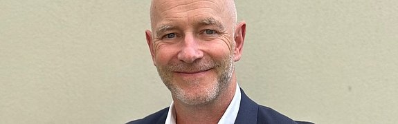 Gregor Zowierucha, CEO of PLATH GmbH & Co. KG, smiles into the camera. He is wearing a dark suit with a white shirt. The background is an office.